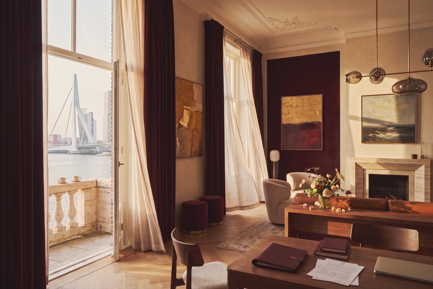 A salon in the house with the balcony doors open to the river and the Erasmus Bridge.